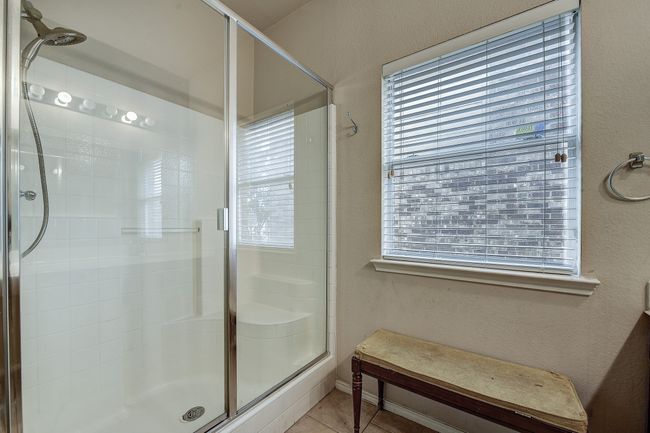 Full bath with a textured wall, a shower stall, plenty of natural light, and tile patterned floors | Image 23