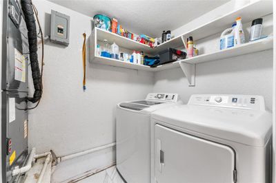 Clothes washing area featuring a textured ceiling and separate washer and dryer | Image 3