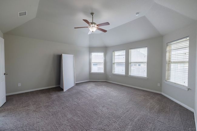 Empty room featuring lofted ceiling, carpet, a ceiling fan, and a smoke detector | Image 10