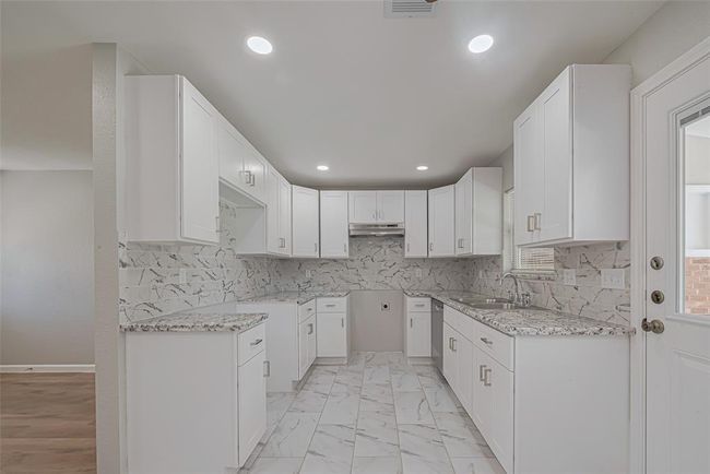 The kitchen includes parallel countertops and an array of overhead cabinets, maximizing space and efficiency. | Image 9