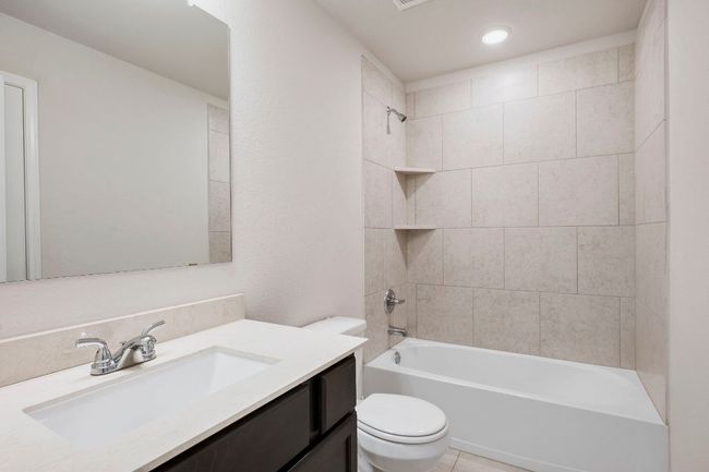 Full bath with tile, counter space, and clean, modern finishes. | Image 14