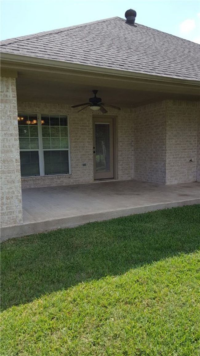 Property entrance with ceiling fan, roof with shingles, a yard, and a patio area | Image 17