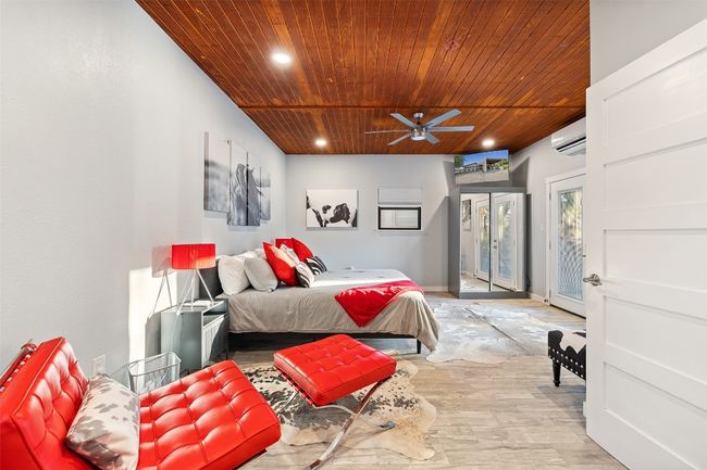 Bedroom with wood ceiling, a wall mounted AC, access to exterior, light wood-type flooring, and recessed lighting | Image 37