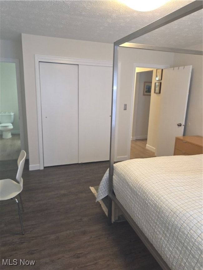 Bedroom with a closet, baseboards, wood finished floors, and a textured ceiling | Image 18