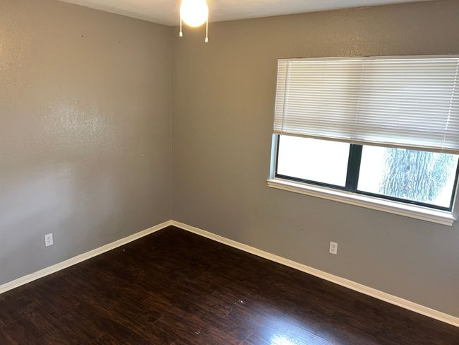 Unfurnished room with dark wood-style floors, plenty of natural light, and ceiling fan | Image 17