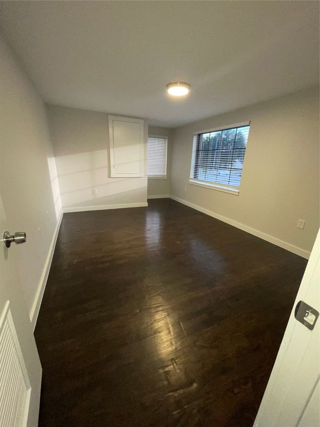 Empty room with dark wood-style flooring and baseboards | Image 9