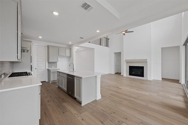 Kitchen featuring tasteful backsplash, open floor plan, light countertops, gray cabinets, and recessed lighting | Image 10