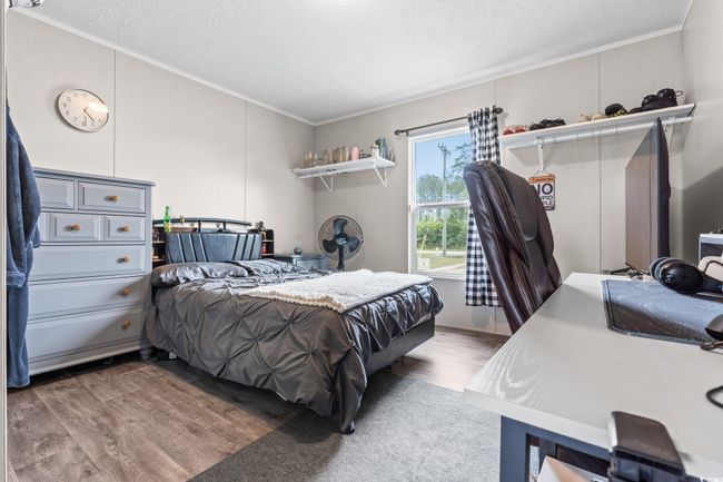 Bedroom featuring ornamental molding, wood finished floors, and a textured ceiling | Image 20