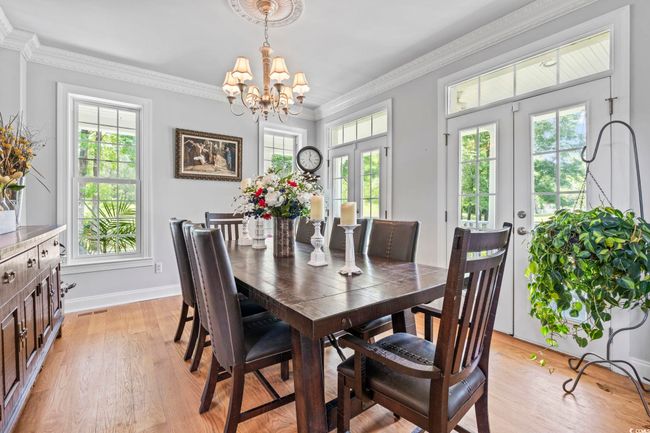 Dining room with french doors, plenty of natural light, a chandelier, light wood finished floors, and crown​​‌​​​​‌​​‌‌​‌‌​​​‌‌​​‌‌​‌​​​​​‌ molding | Image 7