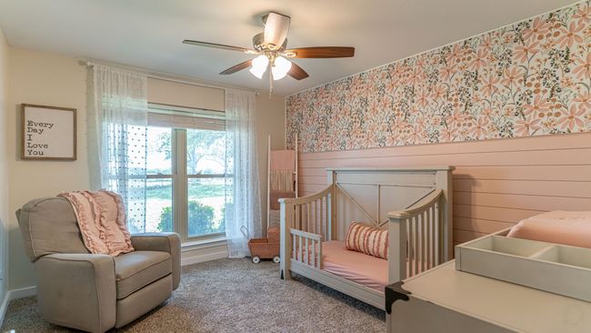 Carpeted bedroom featuring a crib, multiple windows, baseboards, and ceiling fan | Image 21