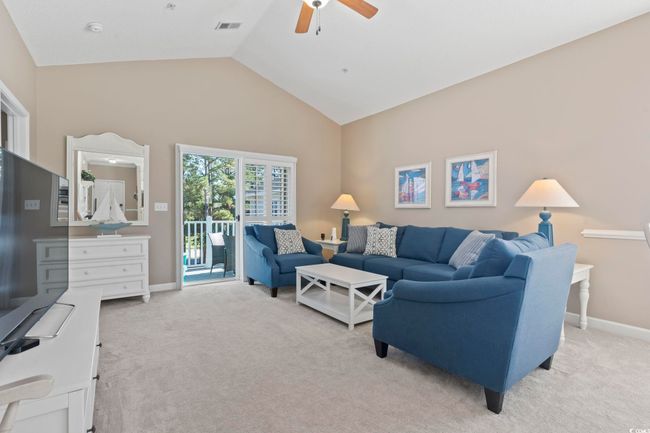 Living room with a ceiling fan, light carpet, lofted ceiling, and baseboards | Image 11
