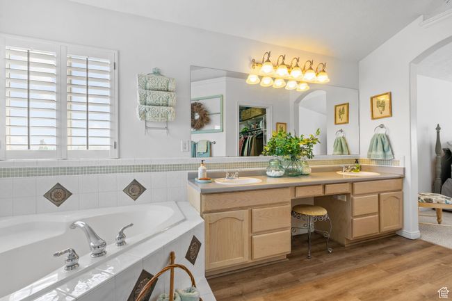 Full bathroom with double vanity, a sink, a bath, and wood finished floors | Image 38