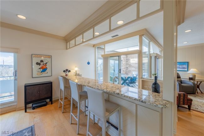 Bar in living room featuring recessed lighting, light wood-style flooring, and light stone counters | Image 17