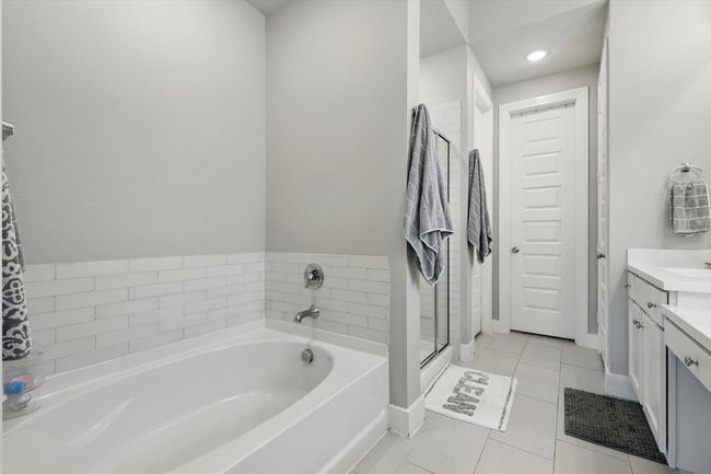 Bathroom with vanity, a garden tub, tile patterned flooring, and a shower stall | Image 15