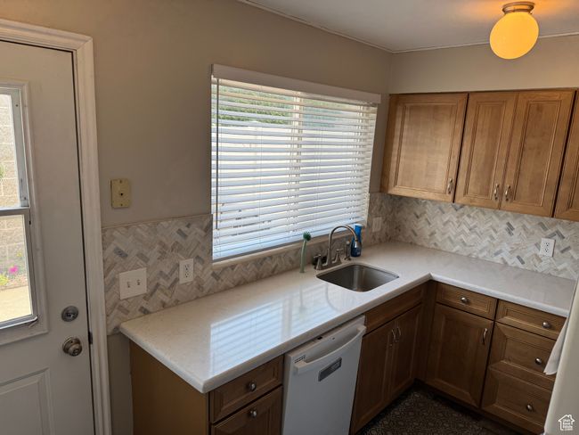 Kitchen featuring dishwasher, light countertops, cabinets, and decorative backsplash | Image 7