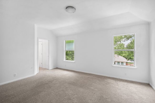 Spare room with plenty of natural light, lofted ceiling, and light carpet | Image 20