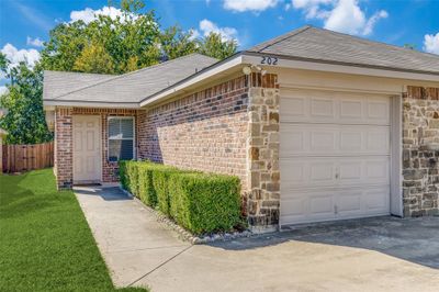 Ranch-style home with a front yard and a garage | Image 3