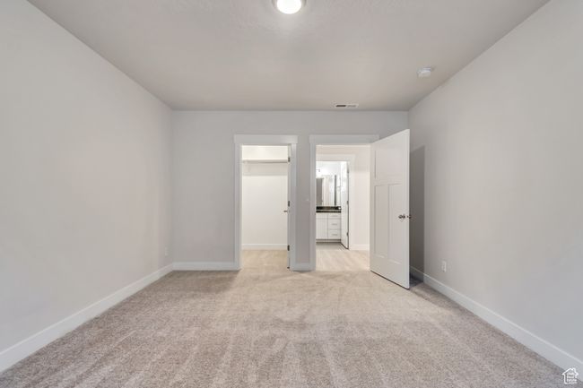 Unfurnished bedroom with light colored carpet and a walk in closet | Image 27