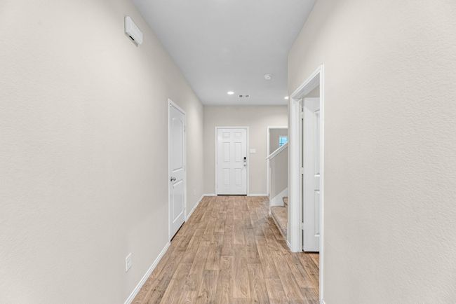 You enter into a foyer that takes you to the 1st floor bedroom, laundry room and ample stairs leading to secondary bedrooms and game room. | Image 9