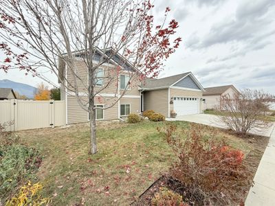 View of front of house featuring a mountain view, a front yard, and a garage | Image 3