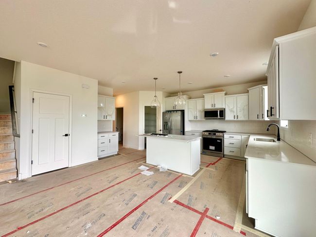 (Photo of an inventory home, actual homes finishes will vary) This spacious kitchen features a large pantry, quartz countertops, LVP floors, stainless appliances and more! | Image 8