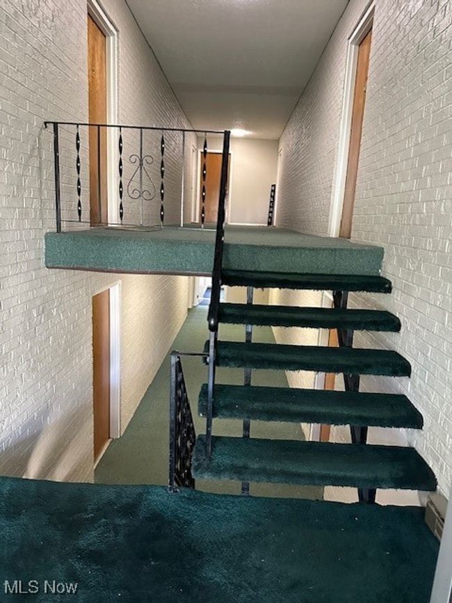 Stairway featuring brick wall and carpet floors | Image 17