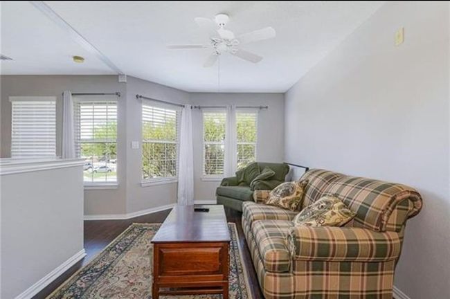 Living room featuring plenty of natural light, ceiling fan, dark hardwood / wood-style flooring, and vaulted ceiling | Image 13