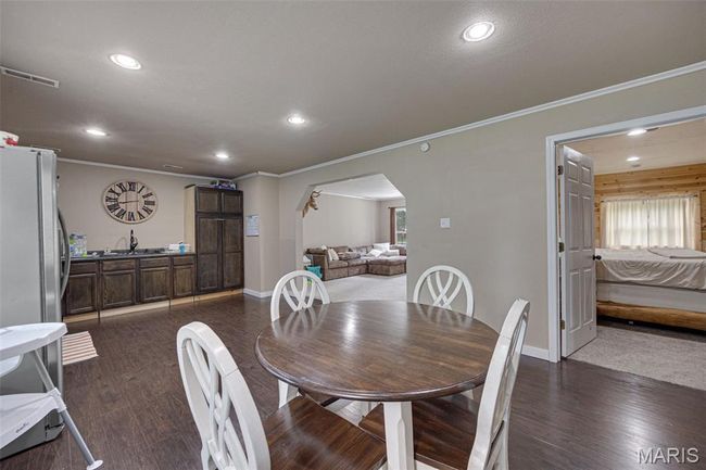 Dining space with arched walkways, recessed lighting, crown molding, dark wood-type flooring, and baseboards | Image 7