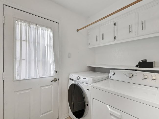 Clothes washing area with washer and dryer and cabinet space | Image 16