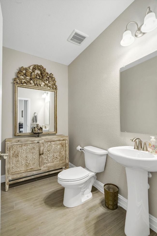 Downstairs half bath features pedestal sink. | Image 7
