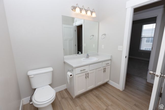 Bathroom with wood finished floors, vanity, baseboards, and toilet | Image 17