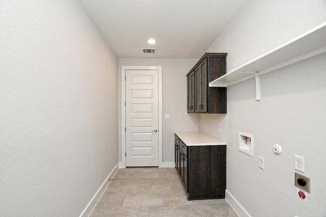 Laundry room featuring hookup for an electric dryer, baseboards, visible vents, cabinet space, and gas dryer hookup | Image 13