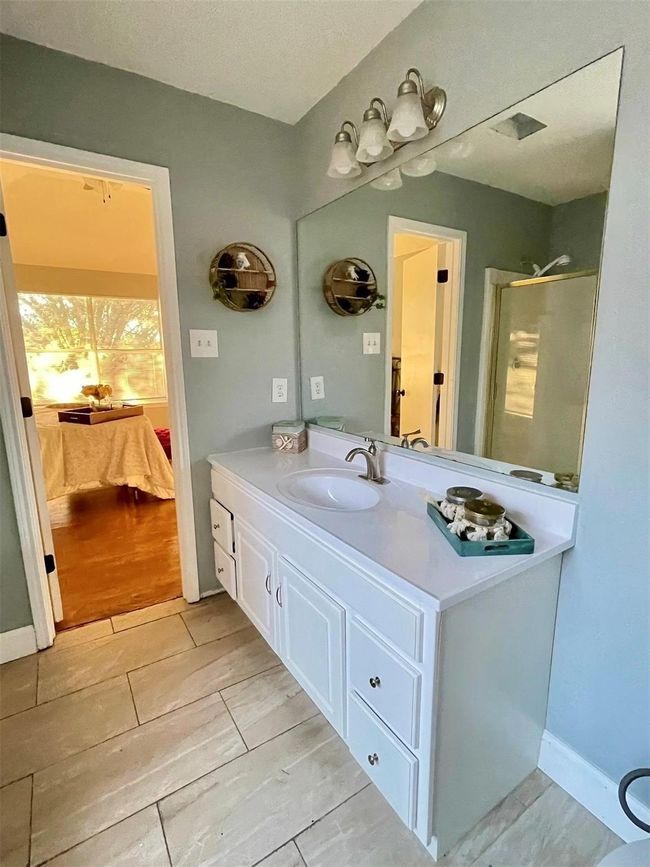 Bathroom with a shower with door, vanity, hardwood / wood-style floors, and a textured ceiling | Image 4