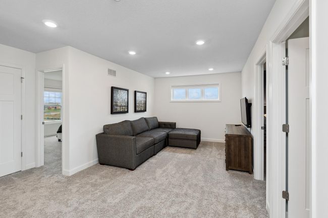 Photo is of the actual model. Located on the upper level, this perfectly sized living space has enough room for a desk, a television, and seating for all. | Image 13