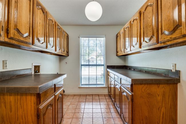 Laundry room featuring cabinet space, hookup for a washing machine, and light tile patterned flooring | Image 11
