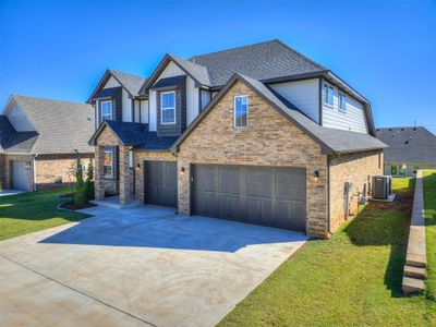 View of front facade with a garage, a front lawn, and central AC | Image 1