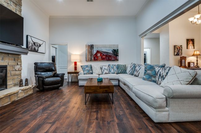 Living room with ornamental molding, luxury vinyl flooring and a fireplace | Image 8