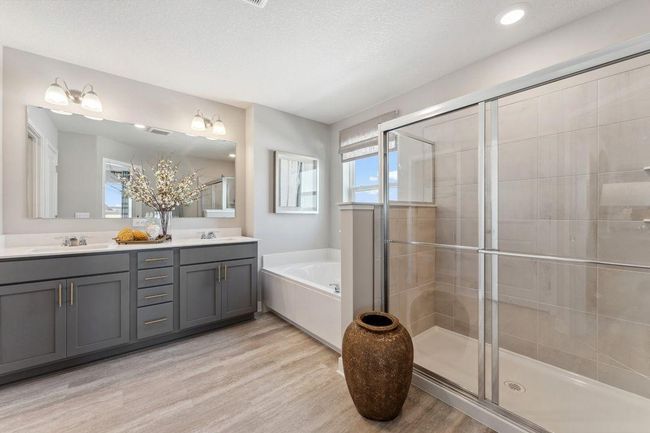 Walk in shower, soaking tub, dual sinks, and private water closet complete the primary bathroom. Photo of model home, colors and finishes will vary. | Image 27