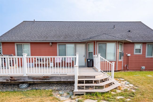 Rear view of property featuring a deck, a lawn, and roof with shingles | Image 24