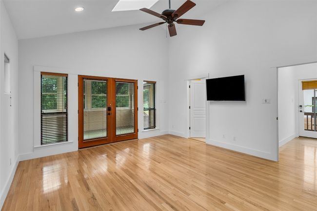 Unfurnished living room featuring french doors, light wood-type flooring, baseboards, high vaulted ceiling, and ceiling fan | Image 18