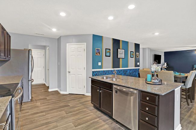 Kitchen is open to breakfast room, living room, and a mudroom by the garage. | Image 10