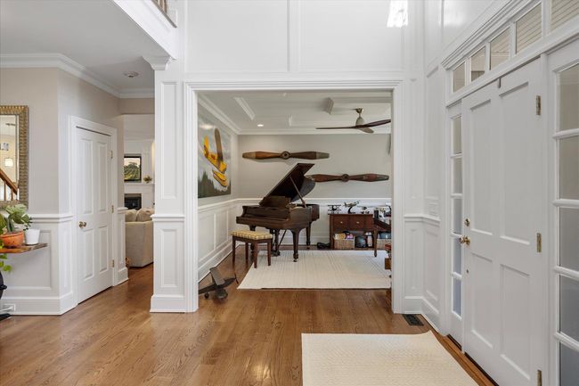 Foyer entrance featuring wainscoting, a decorative wall, crown molding, and wood finished floors | Image 4