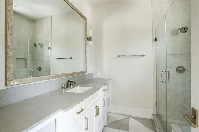 Sleek and refined, this en-suite bath boasts a spacious honed quartz vanity topped with a beautifully framed mirror. A striking glass-enclosed shower completes the space, blending modern design with everyday comfort. | Image 27
