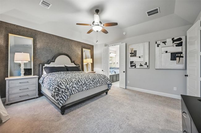 Bedroom featuring light carpet, ensuite bath, and ceiling fan | Image 22