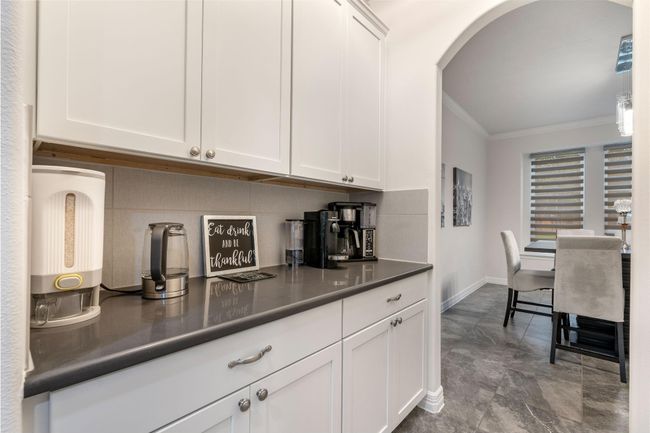 The space opens into a dining area with elegant seating and large windows for natural light. | Image 17