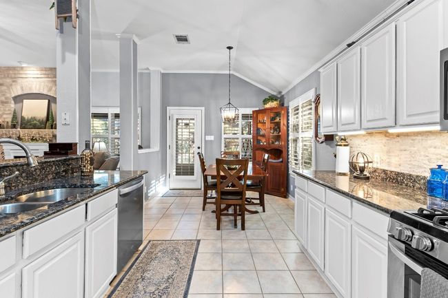 Kitchen featuring sink, crown molding, stainless steel appliances, white cabinets, and light tile patterned​​‌​​​​‌​​‌‌​‌‌​​​‌‌​​‌‌​‌​​​​​‌ flooring | Image 14