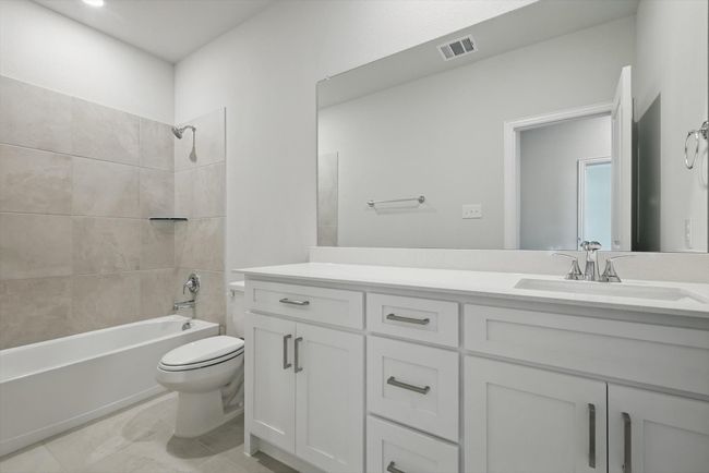 Bathroom with visible vents, toilet, vanity, and shower / bath combination | Image 17