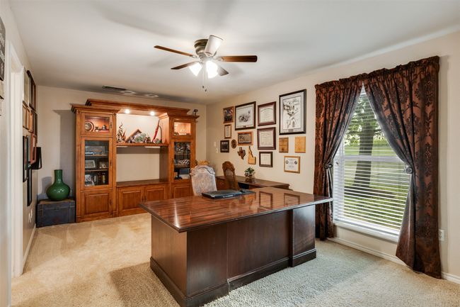 Home office with a ceiling fan, baseboards, and light colored carpet | Image 24