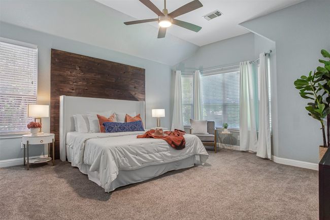Carpeted bedroom featuring lofted ceiling, multiple windows, baseboards, and ceiling fan | Image 8