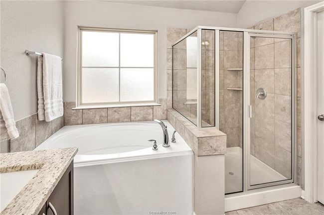 Bathroom featuring plenty of natural light, plus walk in shower, vanity, and lofted ceiling | Image 18